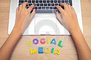 Business woman hand using Laptop pc with social media letters , social media concept