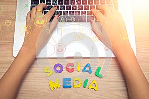 Business woman hand using Laptop pc with social media letters , social media concept