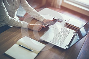 Business woman hand working laptop computer on wooden desk.