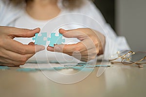 Business woman hands assembling puzzle details concept of finding solution solving problem top view