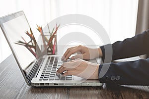 Business woman hands typing on laptop keyboard in office