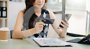 Business woman hands using smartphone and holding credit card as Online shopping