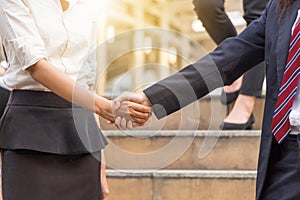 Business woman handshake at city background.