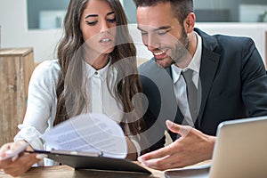 Business woman and handsome man discussing documents during a meeting in office