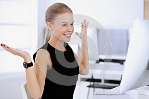 Business woman happy and excited while working with computer in modern office. Secretary or female lawyer looks