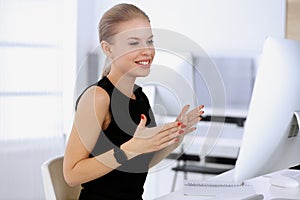 Business woman happy and excited while working with computer in modern office. Secretary or female lawyer looks
