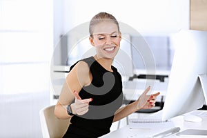 Business woman happy and excited while working with computer in modern office. Secretary or female lawyer looks