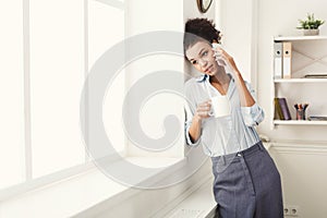 Business woman has phone talk near office window