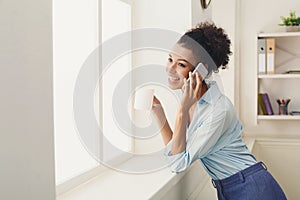 Business woman has phone talk near office window