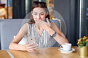 Business woman having surprised expression after recieving message in coffee shop. Wow effect