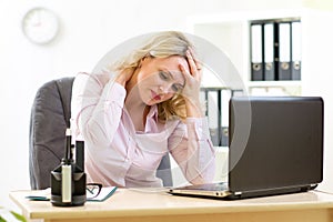 Business woman with headache having stress in the office photo