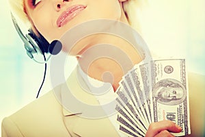 Business woman with headset holding dollars