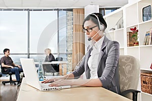 Business woman with headset in an office