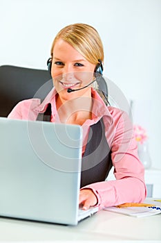 Business woman with headset working on laptop