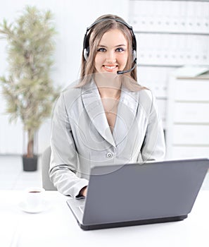 Business woman with headset working on laptop.