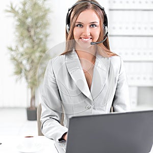 Business woman with headset working on laptop.