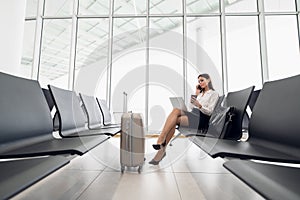 Business woman on her smart phone waiting at the airport