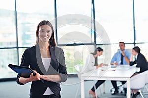 Business woman with her staff in background at office