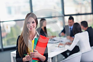 Business woman with her staff in background at office