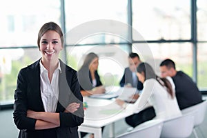 Business woman with her staff in background at office