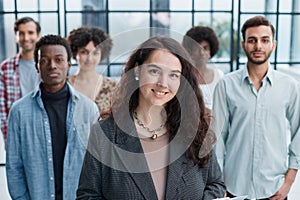 business woman with her staff in background at office photo