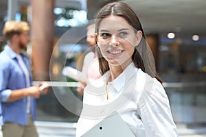 Business woman with her staff, people group in background at modern bright office.