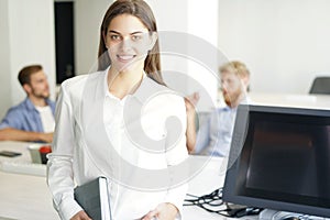 Business woman with her staff, people group in background at modern bright office indoors.