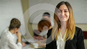 Business woman with her staff, people group in background at modern bright office indoors