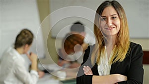 Business woman with her staff, people group in background at modern bright office indoors