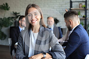 Business woman with her staff, people group in background at modern bright office indoors