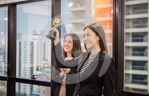 Business woman holding award trophy at meeting room, Celebration success happiness team concept