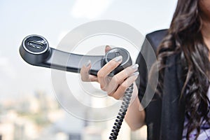 Business woman is holding the black IP Phone handset