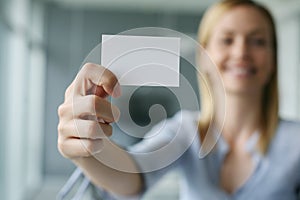 Business woman holding a blank business card.