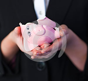 Business woman holding a broken piggy bank photo