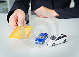 Business woman is holding credit card in hand to buy new car or invest in car, business financial concept. copy-space in white