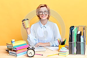 Business woman holding a cup of coffee loking at the camera