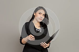 Business woman holding folder while imagining expression