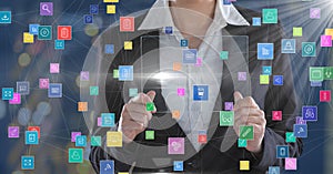 Business woman holding futuristic device surrounded by colorful icons