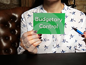 Business Woman holding green business card with written text Budgetary Control - closeup shot