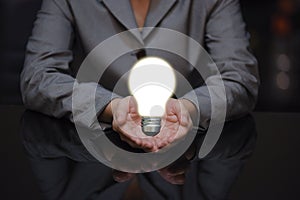 Business woman holding hand with bulb on hand