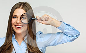 Business woman holding magnifying glass behind eyes.