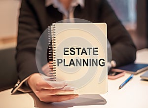 Business woman holding a notebook with the text: Estate Planning