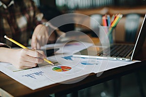 Business woman holding a pencil to analyze the marketing plan wi