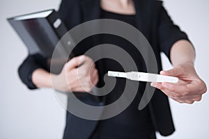 Business woman holding pregnancy test