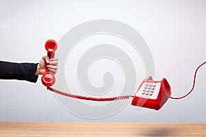 Business woman holding the red phone