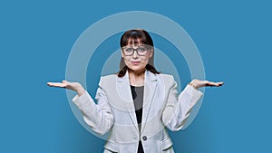 Business woman holding two hands with empty open palms on blue background