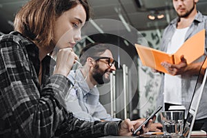 Business woman holds glasses in his hand and thinks on new stratup together with his team. Coworking team discussing new startup