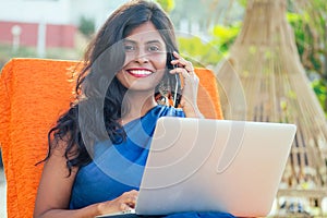 Business woman india asian female freelancer sitting in cafe. woman in indian blue stylish saree sari working on laptop