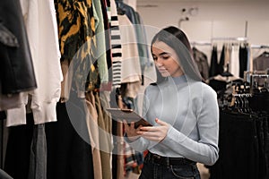 Business woman inspecting garment in her clothes shop. Beautiful shop owner conducting a control check in her clothing