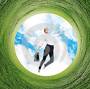 Business woman jumps in rotated field with green grass.